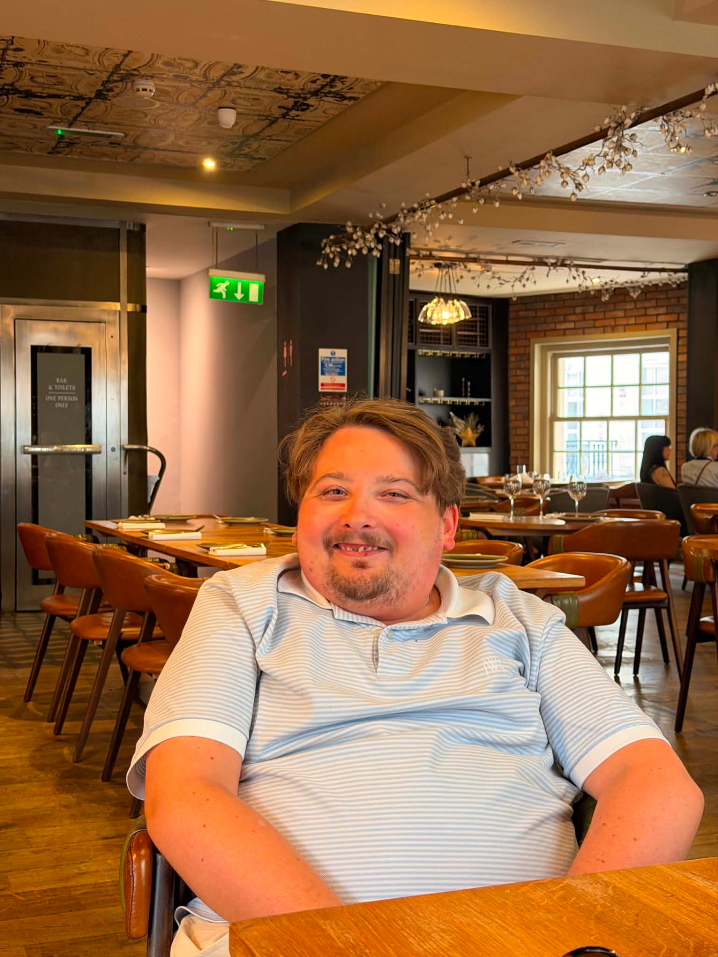 Léopold, jeune habitant du quartier, souriant attablé au restaurant